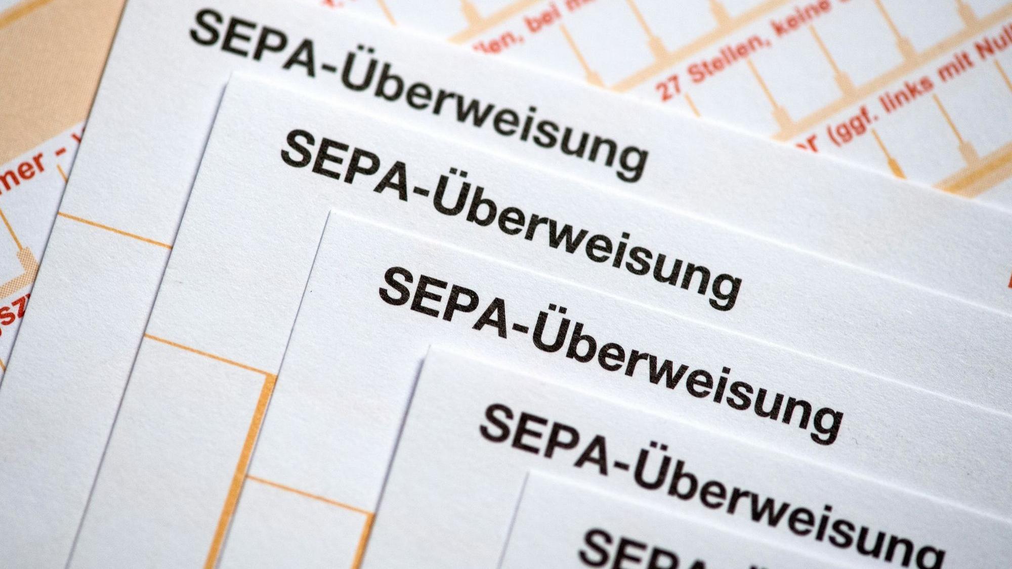 SEPA-Überweisungsscheine liegen auf einem Tisch