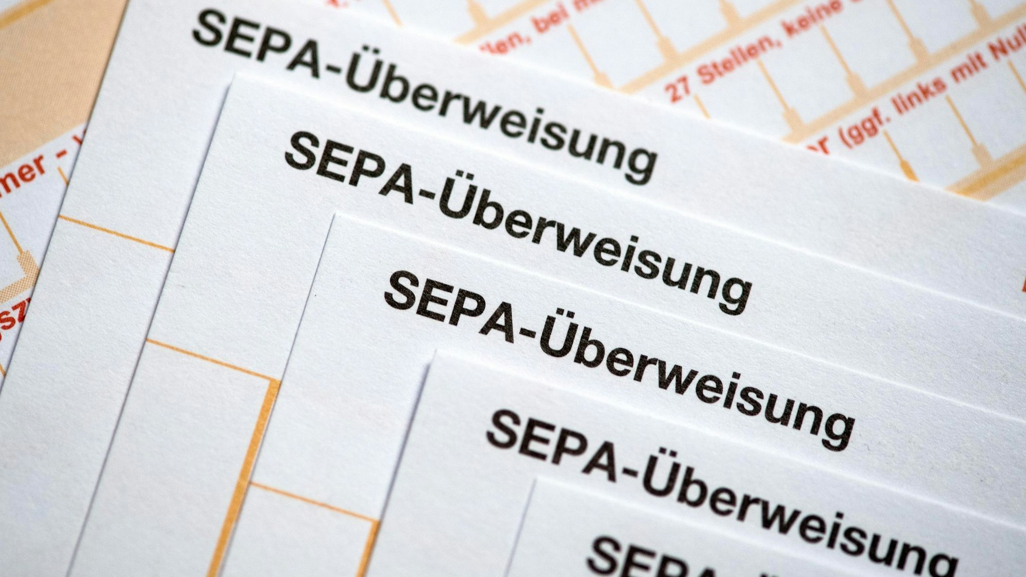 SEPA-Überweisungsscheine liegen auf einem Tisch