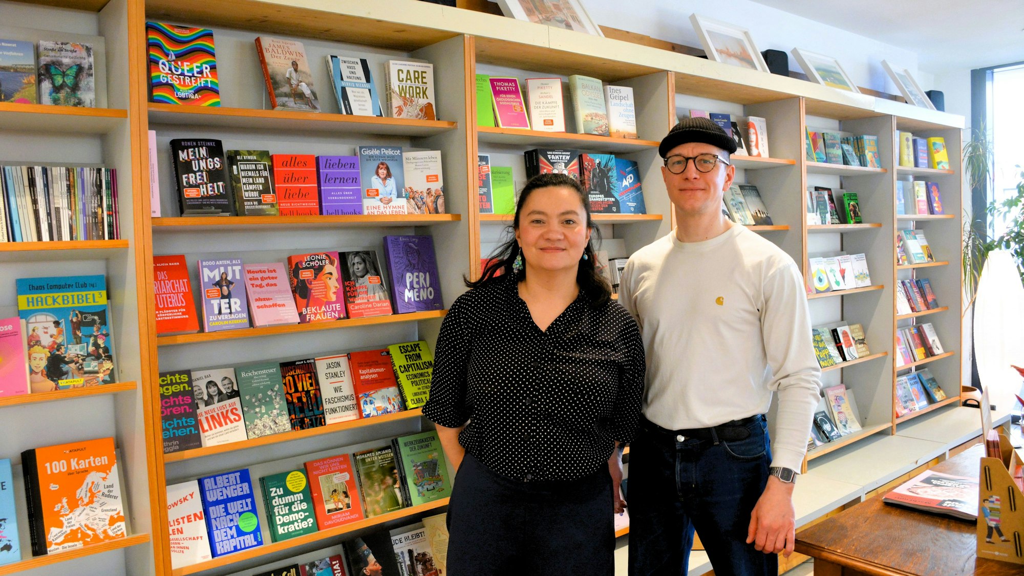 Ein Mann und eine Frau stehen vor einem Bücherregal.