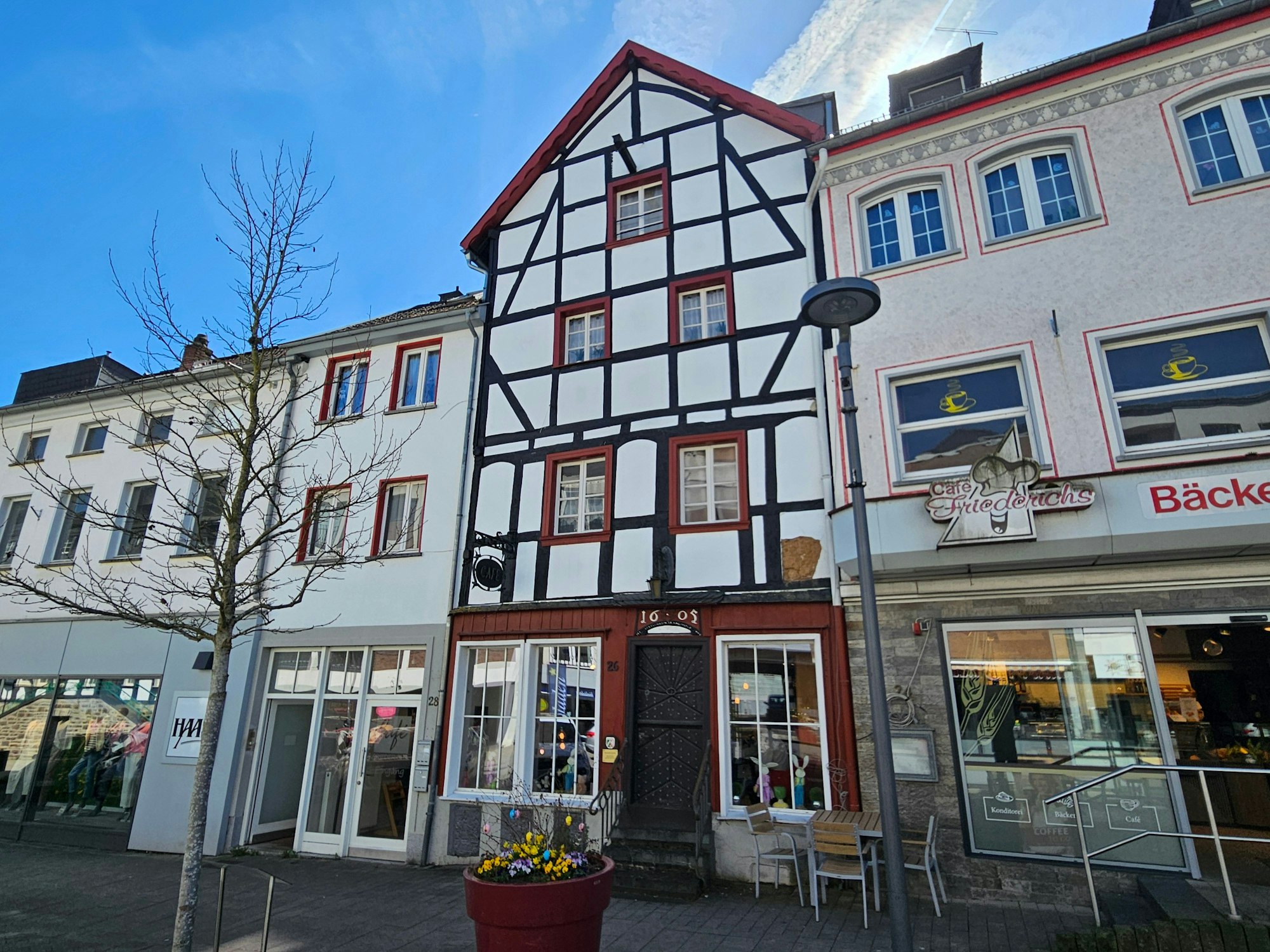 Blick auf einer Häuserfront mit einem Fachwerkhaus in der Mitte.