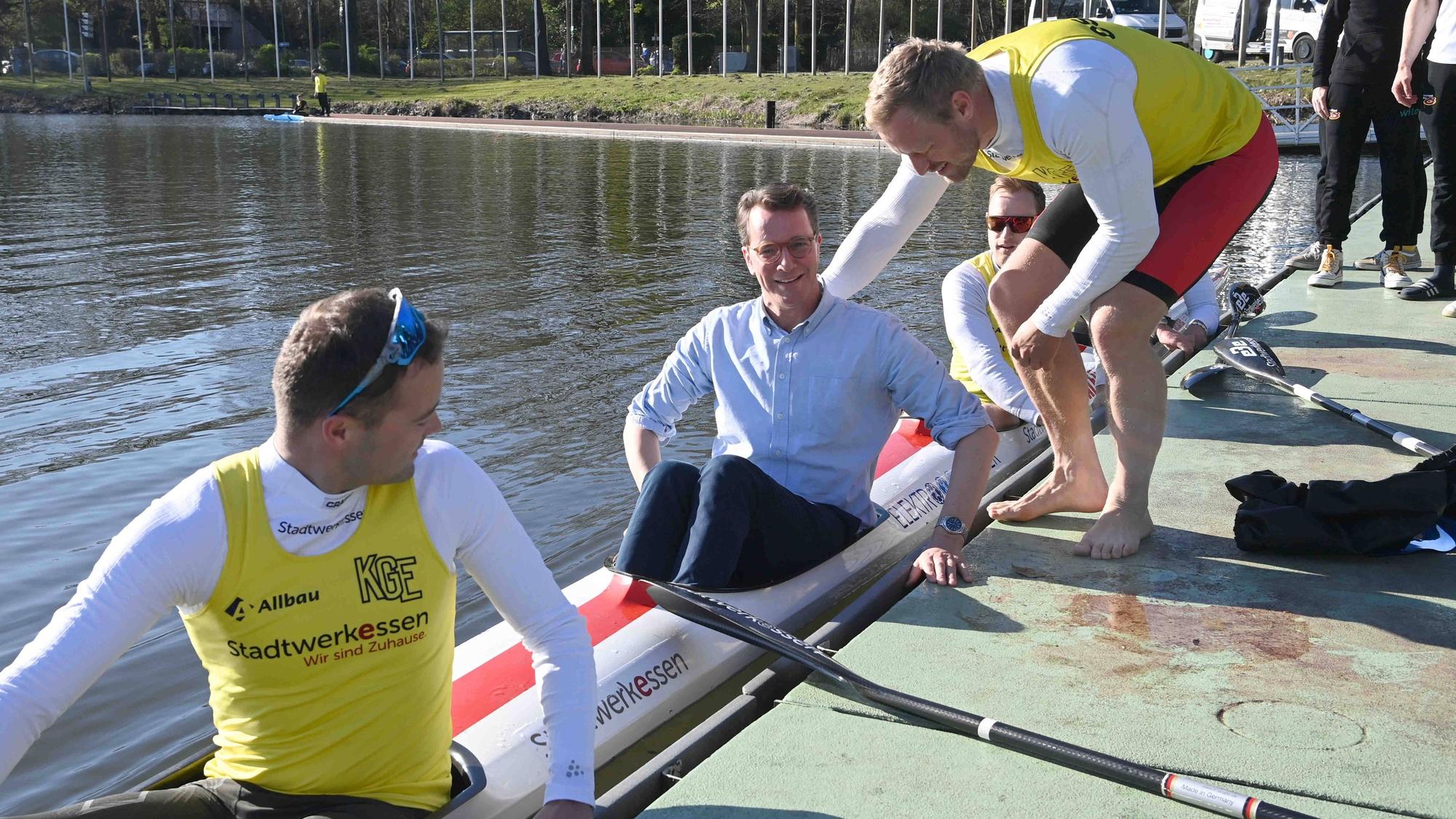 NRW-Ministerpräsident Hendrik Wüst wirbt nach Kräften für Olympia an Rhein und Ruhr - hier im deutschen Kajak-Vierer, gut gesichert vom Essener Merhfach-Olympiasieger Max Rendschmidt.