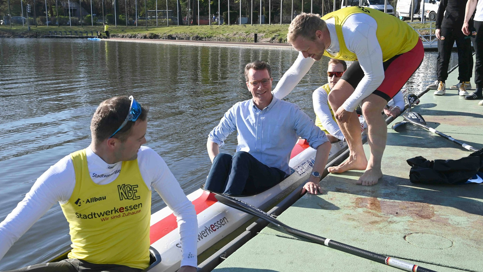 NRW-Ministerpräsident Hendrik Wüst wirbt nach Kräften für Olympia an Rhein und Ruhr - hier im deutschen Kajak-Vierer, gut gesichert vom Essener Merhfach-Olympiasieger Max Rendschmidt.