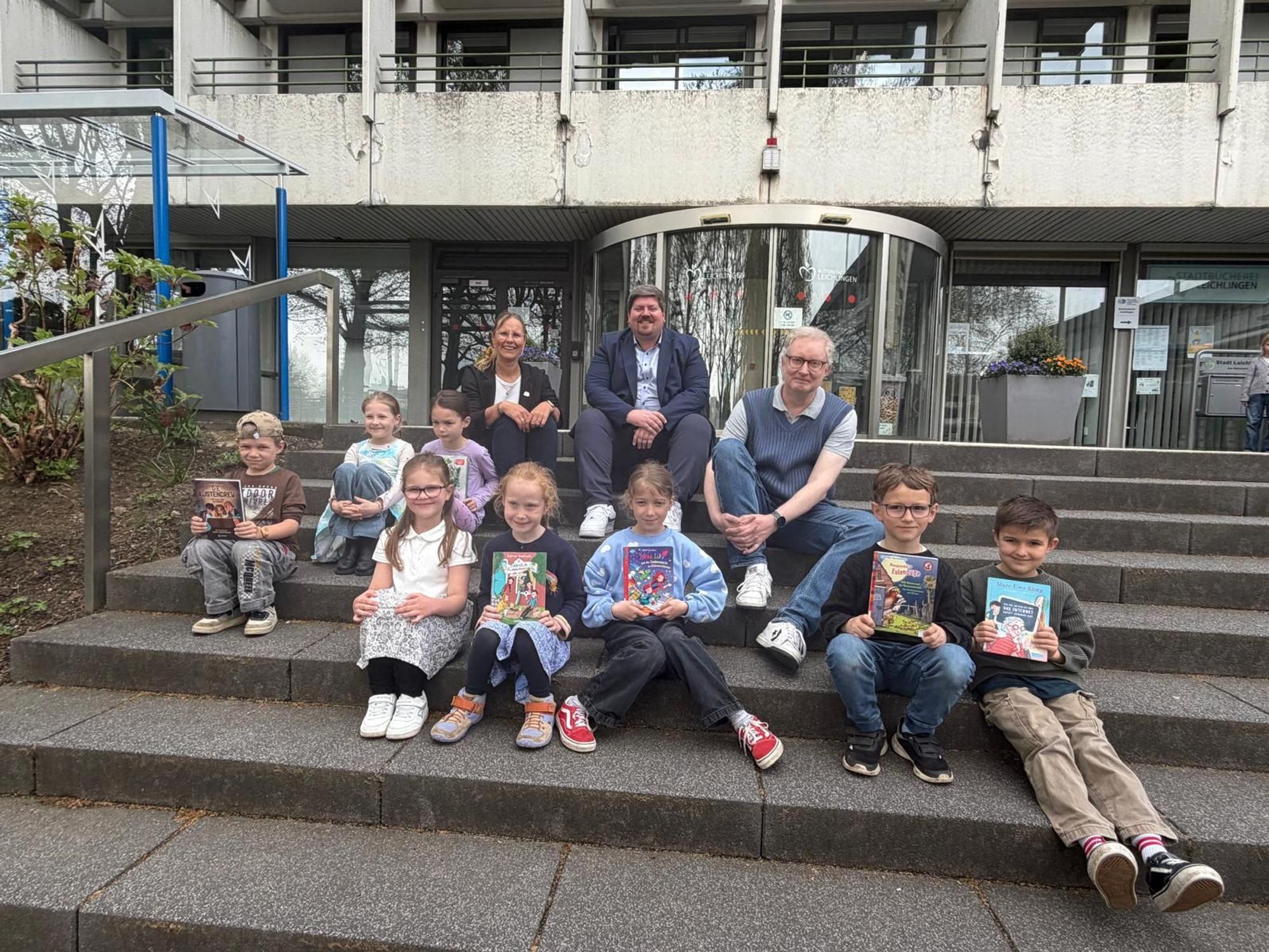 Die Teilnehmer der 1. und 2. Klassen, sitzen vor dem Rathaus.