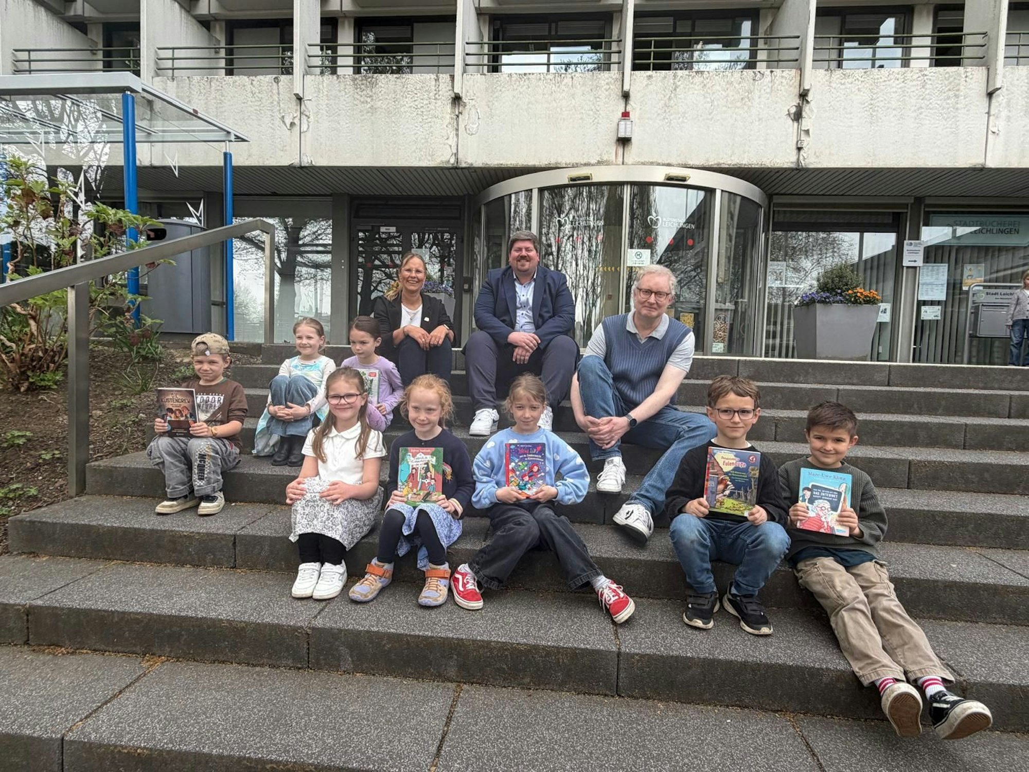 Die Teilnehmer der 1. und 2. Klassen, sitzen vor dem Rathaus.