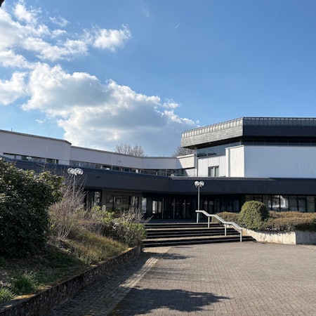 Das Foto zeigt das Rathaus der Gemeinde Reichshof in Denklingen samt Vorplatz an einem sonnigen Nachmittag.