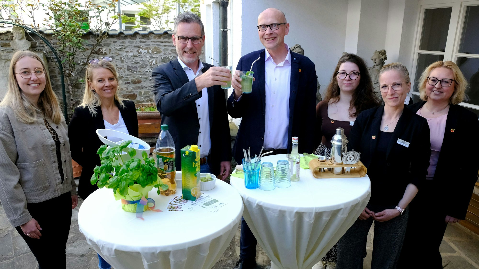 Die Bürgermeister Norbert Crumpen (3.v.l.) und Sebastian Glatzel stoßen mit einem Kräuter-Cocktail an. Um sie herum stehen Mitarbeiterinnen aus den Orga-Teams der beiden Kommunen.