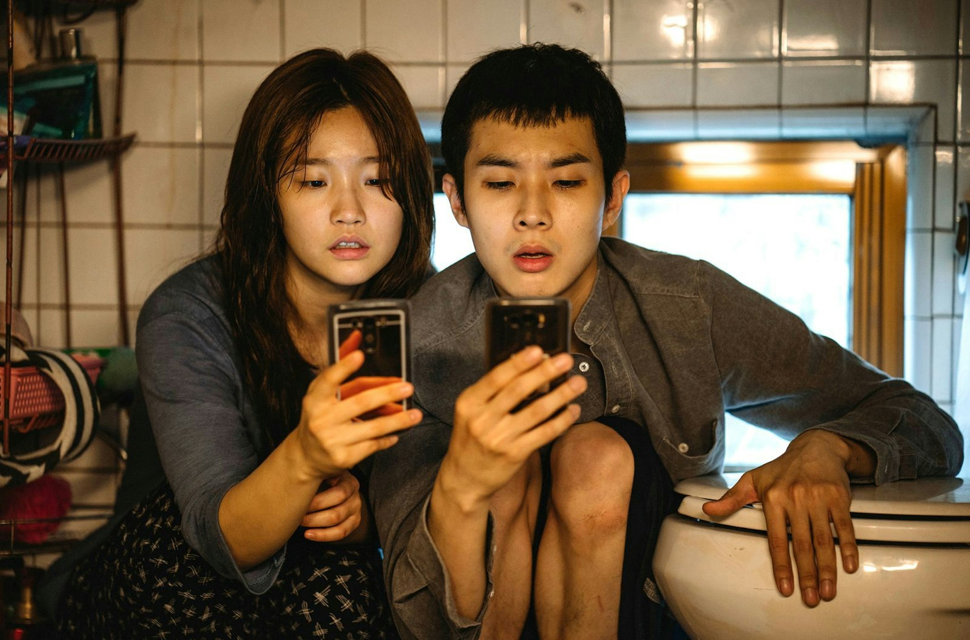 Für kostenloses Internet kriechen Ki-jung (Park So-dam) und ihr Bruder Ki-woo (Choi Woo-shik) in die entlegensten Ecken ihrer Behausung. (Bild: ARD Degeto Film/KochMedia)