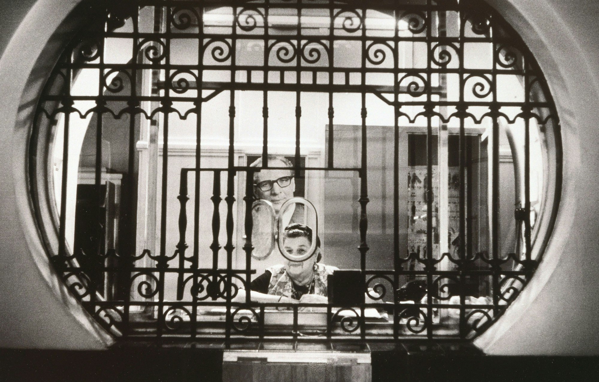 Eine Frau sitzt hinter Gittern in einem Pförtnerhaus.