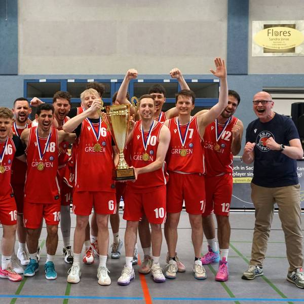 Die Erftbaskets Bad Münstereifel jubeln mit Landrat und Bürgermeister, zwei Spieler halten einen Pokal in die Höhe.