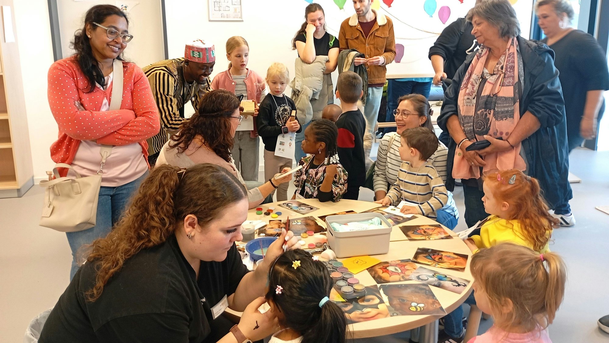 Zu sehen sind Frauen, die Kinder schminken.