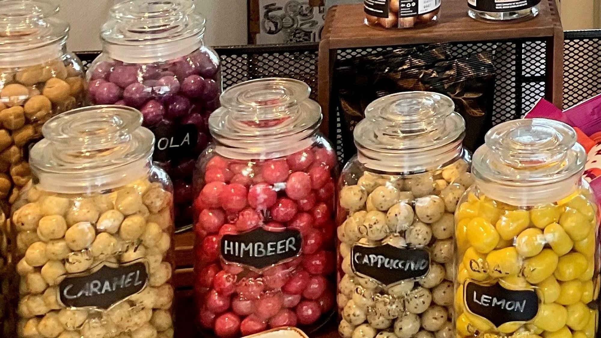 Gläser voller runder Lakritze in verschiedenen Geschmacksrichtungen stehen nebeneinander.