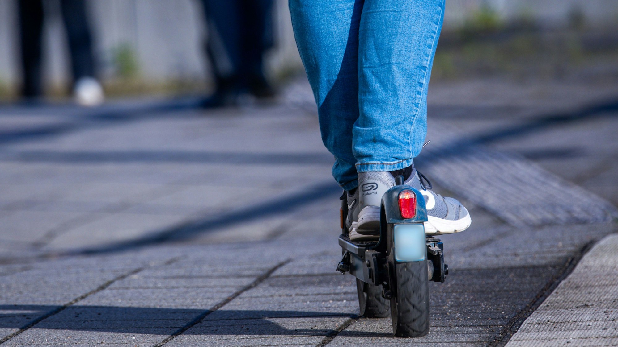 Ein Mensch fährt mit seinem E-Scooter.