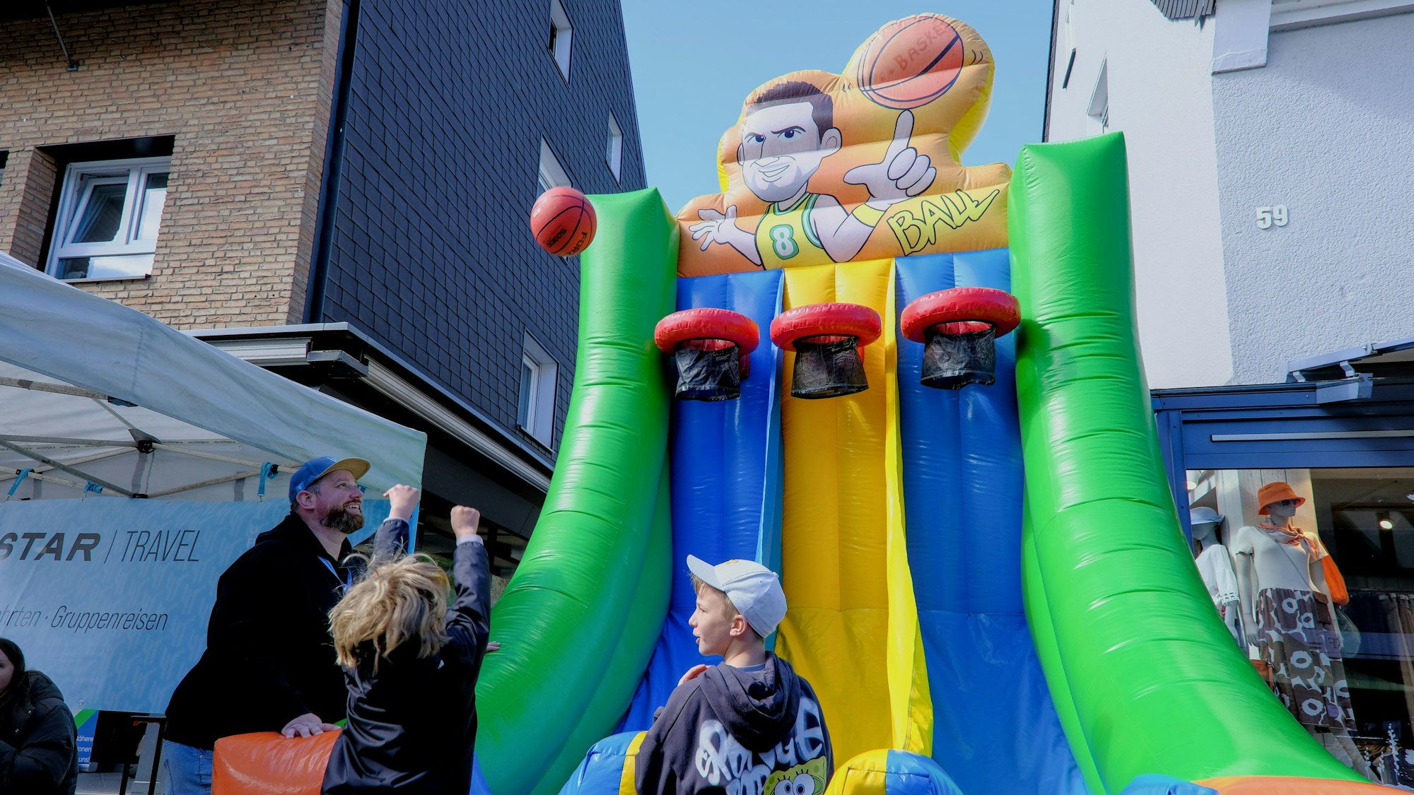 Ein kleiner junge schmeißt einen Ball in einen Basketballkorb.