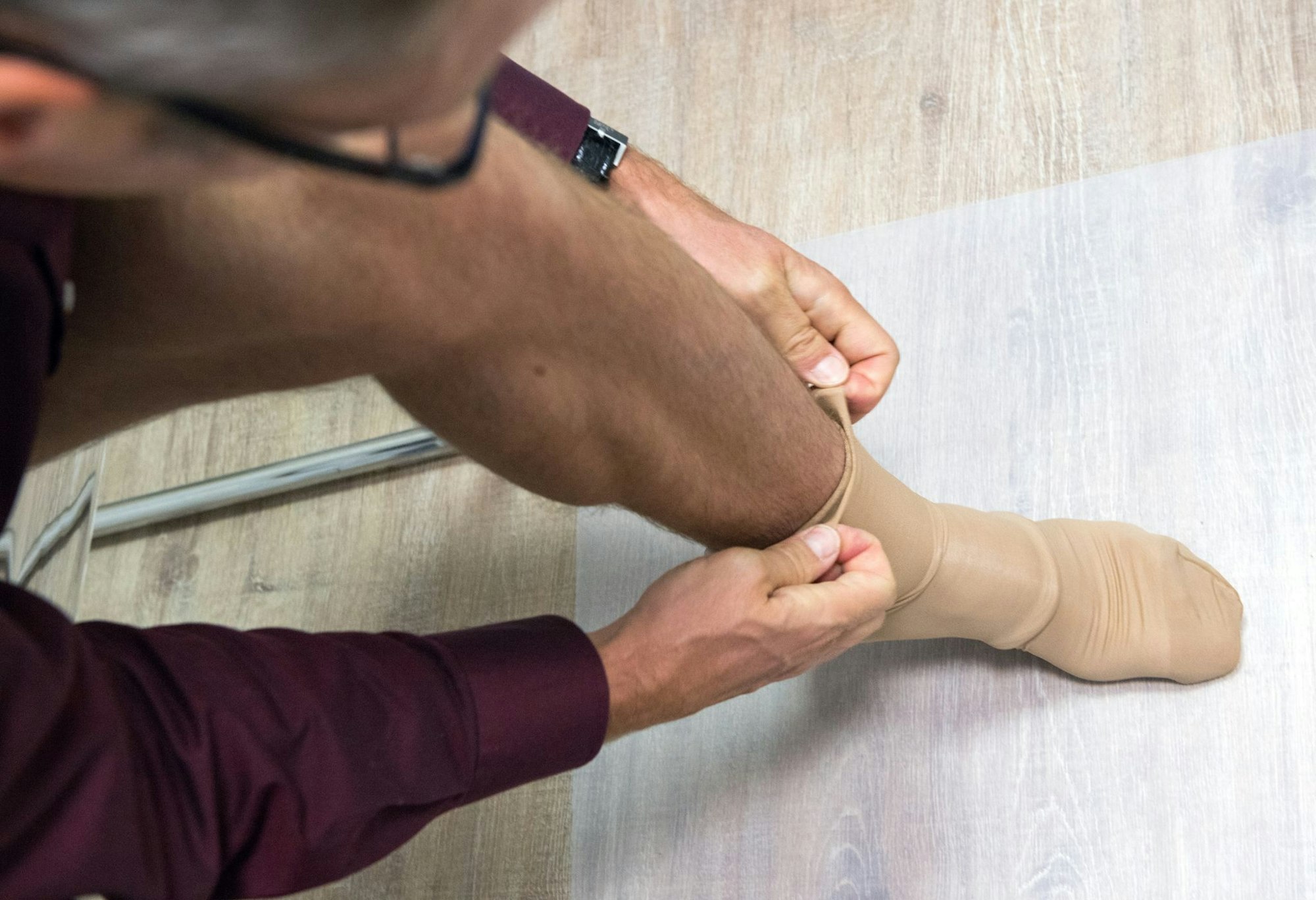 Ein Mann zieht Kompressionsstrümpfe an