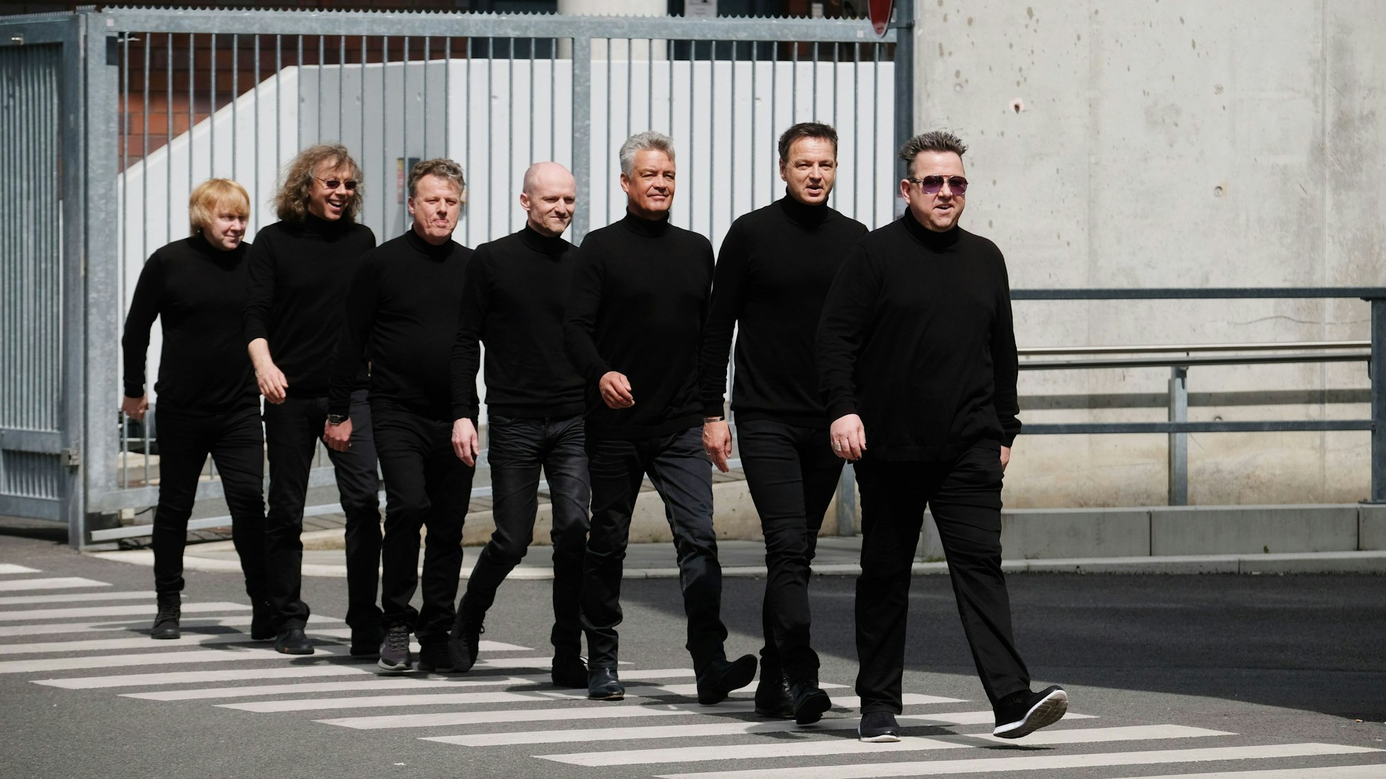 Mitglieder der Band Die Prinzen gehen über einen Zebrastreifen.