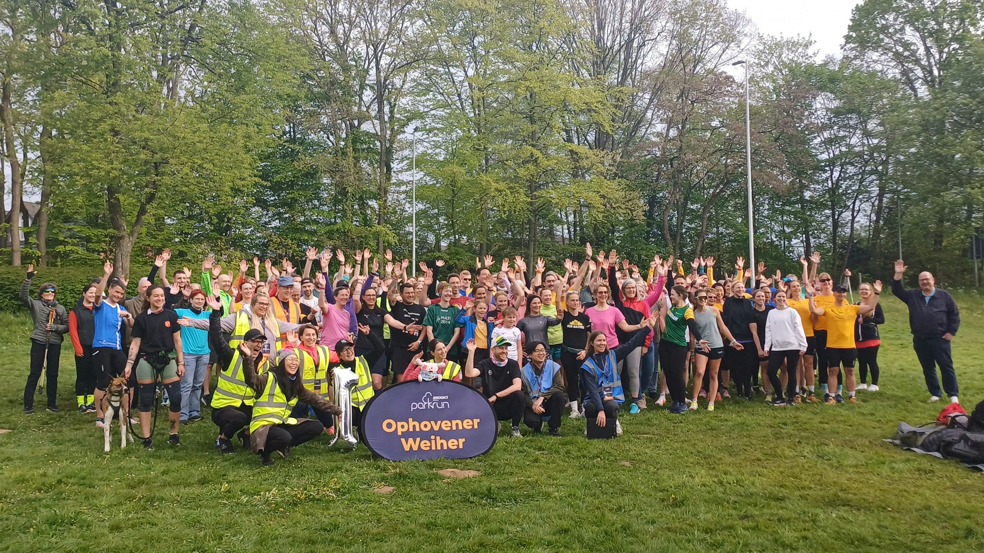 Läuferinnen und Läufer stehen in einem Park.