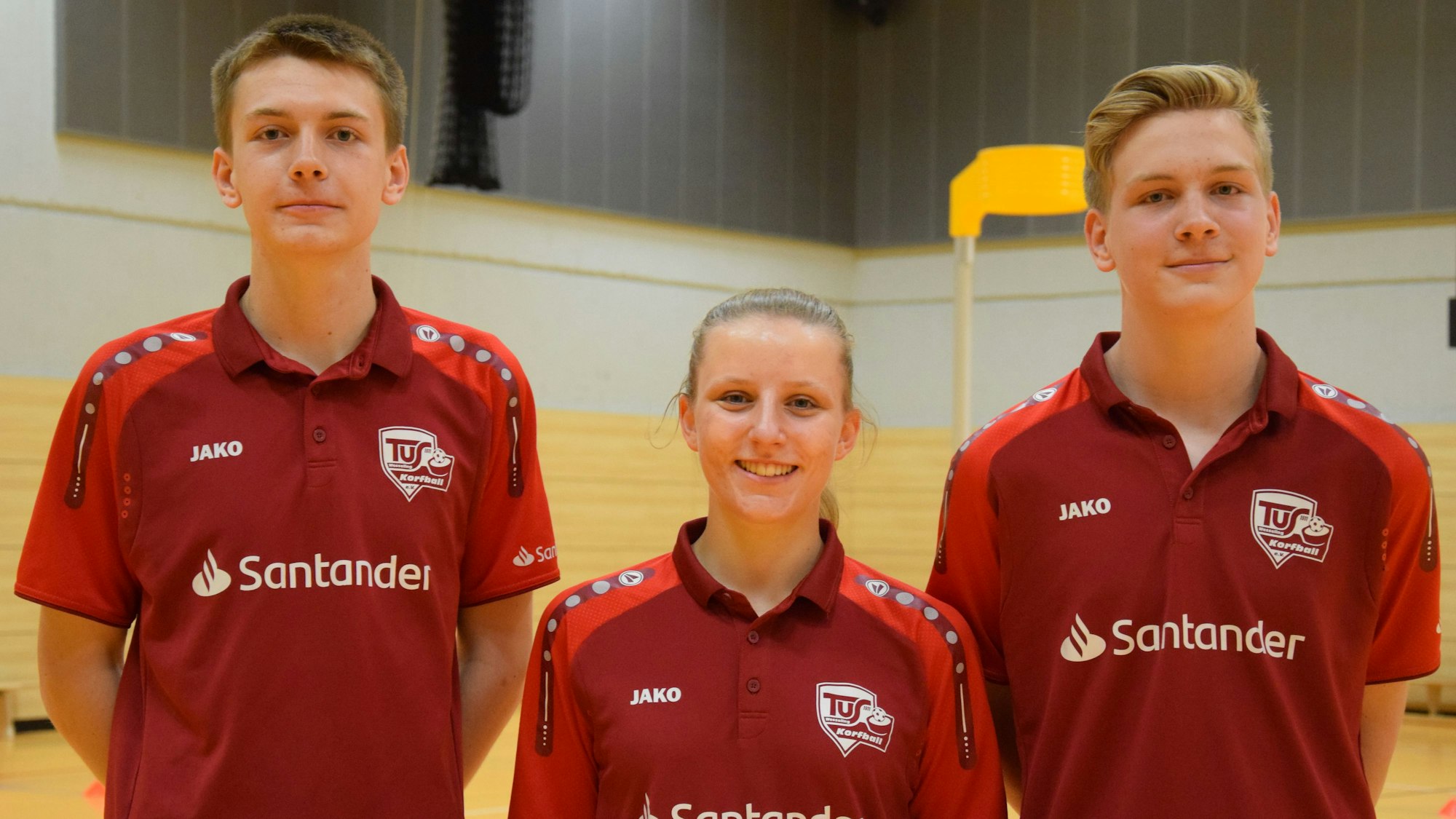 Das Foto zeigt eine Sportlerin und zwei Sportler.