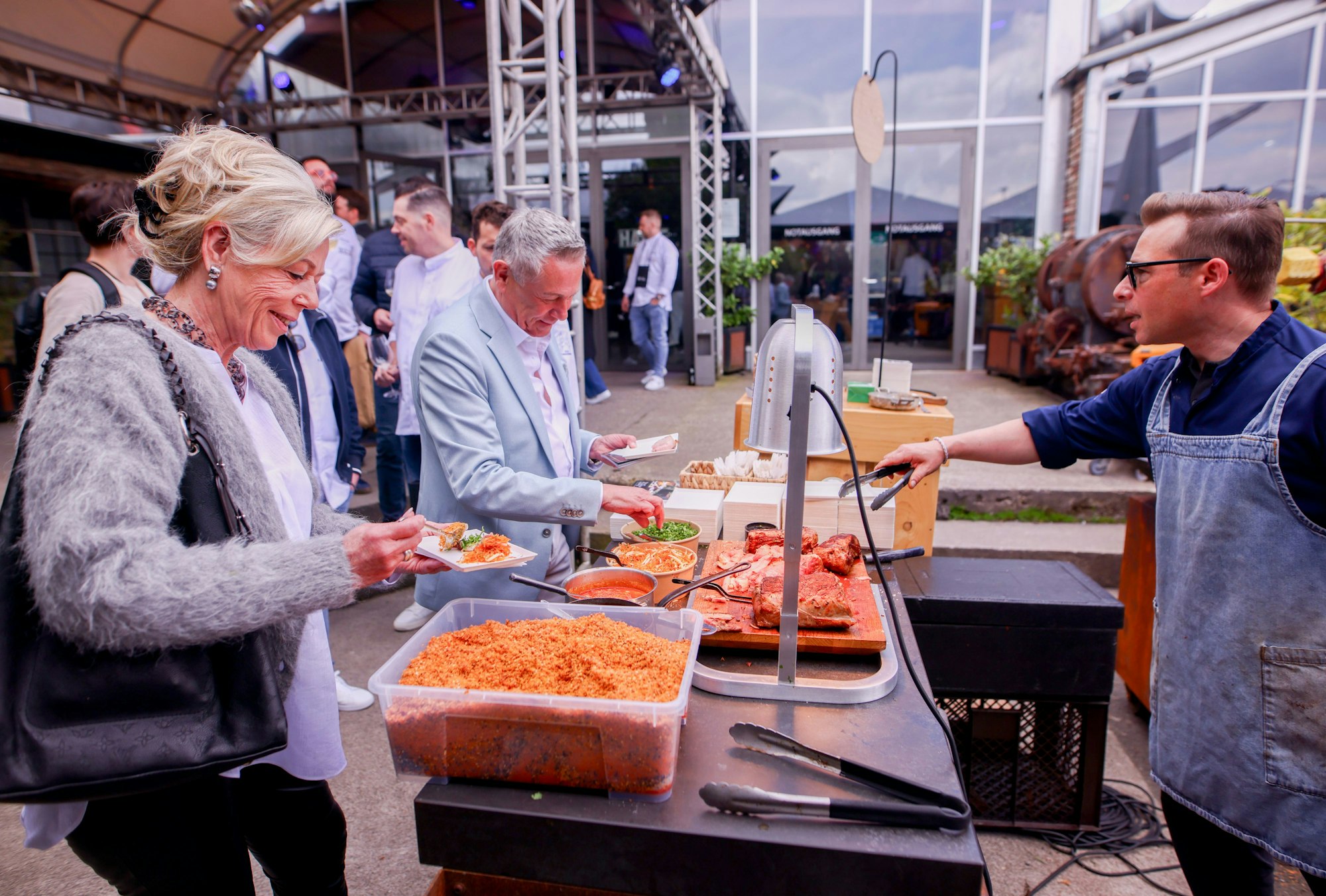 Das Ehepaar Schievelkamp bekommt eine Portion geröstetes Kalb auf asiatische Art vom Leipziger Koch Nils Jorra.