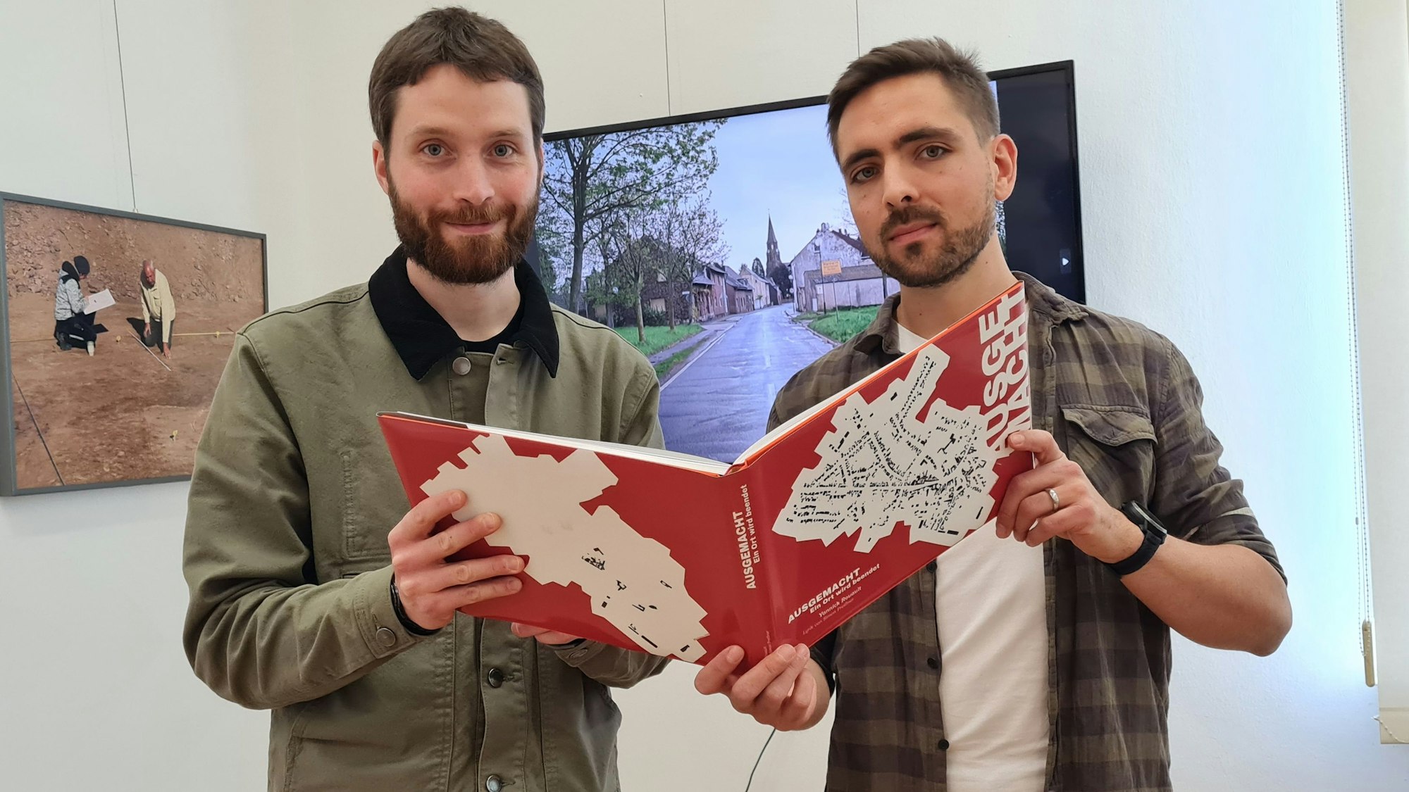 Zu sehen sind Yannick Rouault und Simon Preissner, sie halten den Bildband fest.