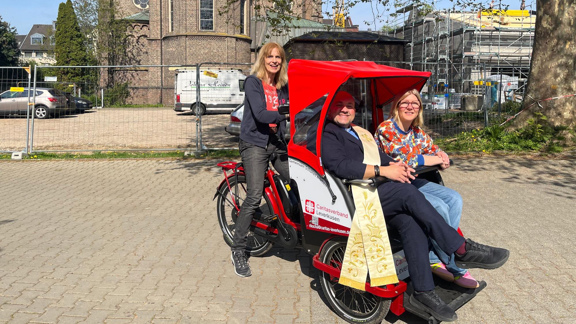 Regina Moka fährt das Rad mit Toni Rizza und Esther Henning.