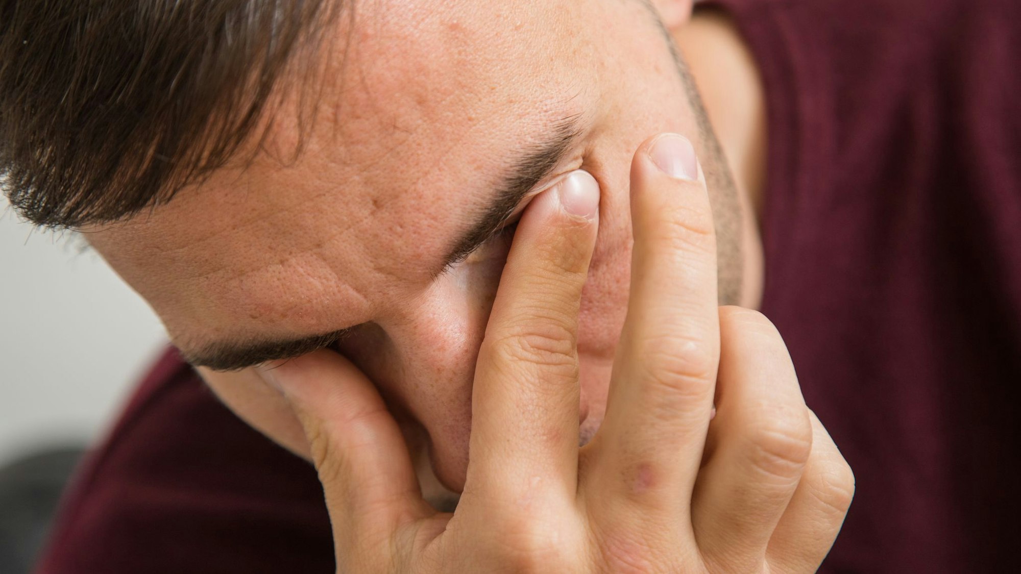 Mann fässt sich an die Augen