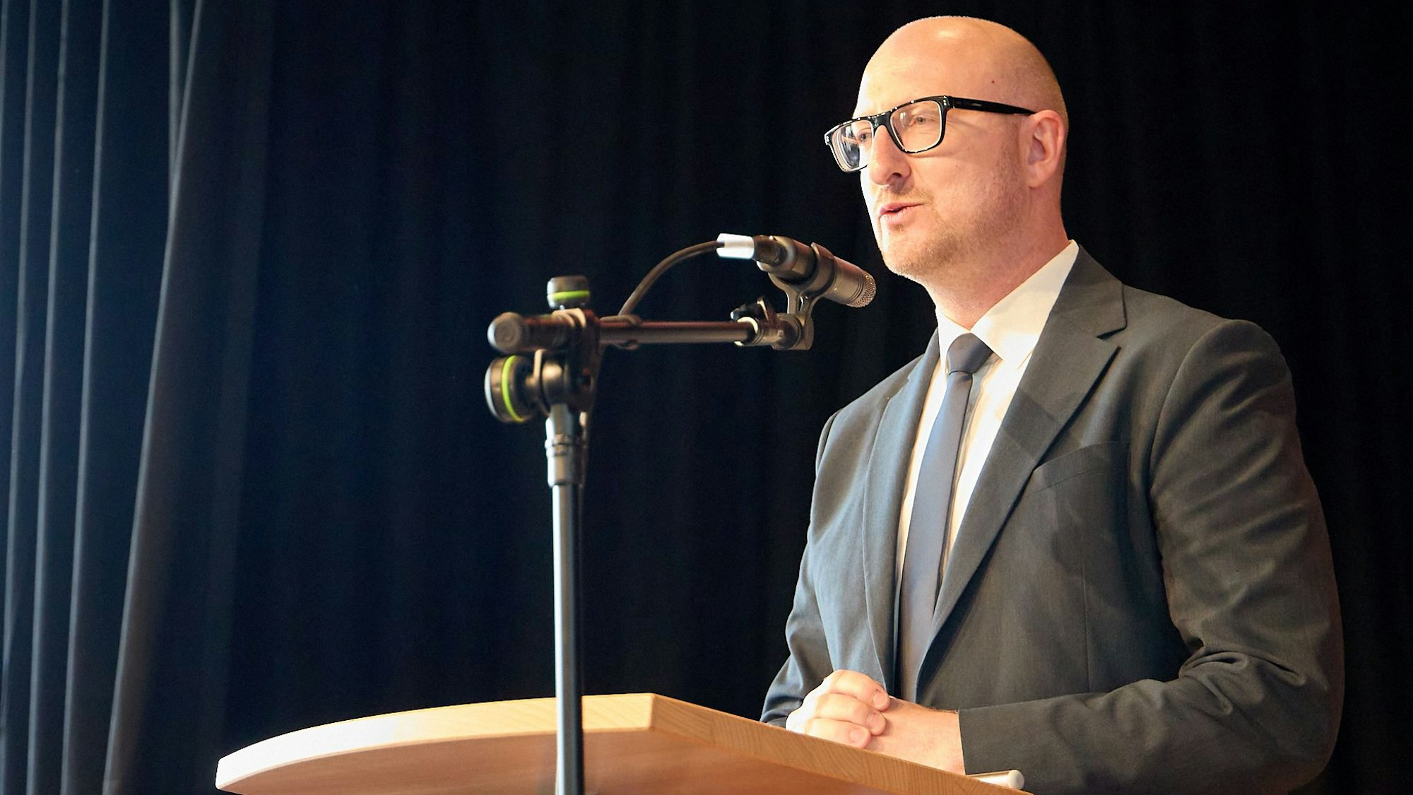 Ingo Pfennings steht hinter ein Mikrofon am Rednerpult.