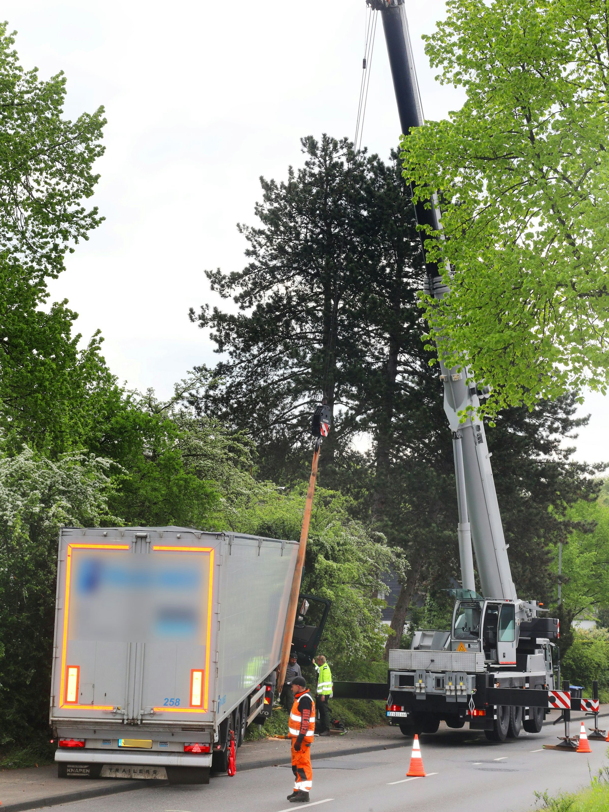 Ein Autokran hat einen Sattelzug am Haken.