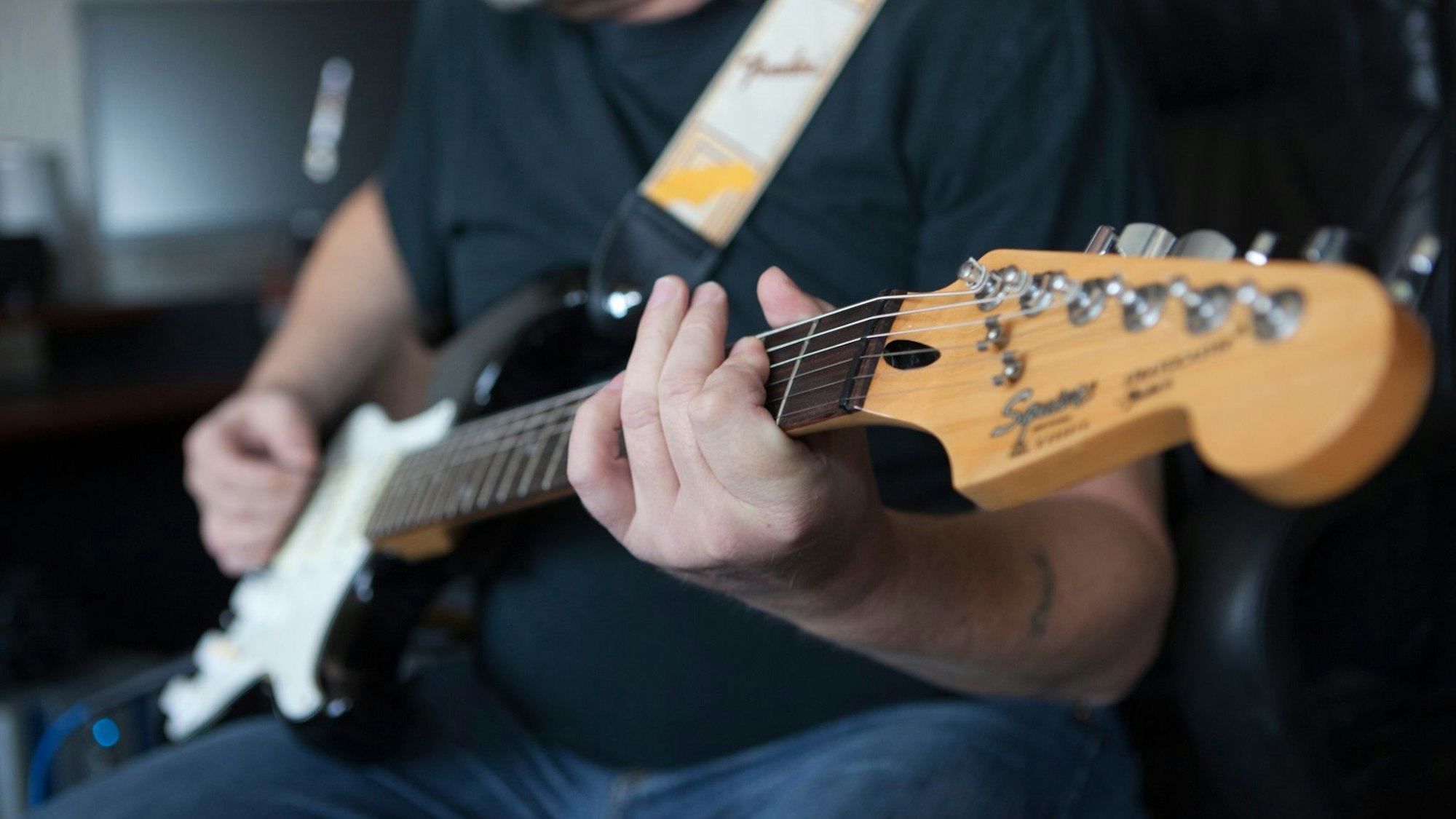 Mann spielt auf einer E-Gitarre