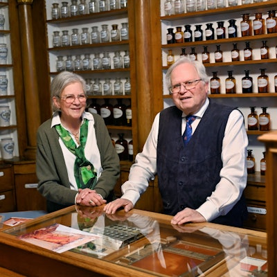Gertrudis und Theodor Symann stehen im Apothekenmuseum Bad Münstereifel gemeinsam hinter der Verkaufstheke.