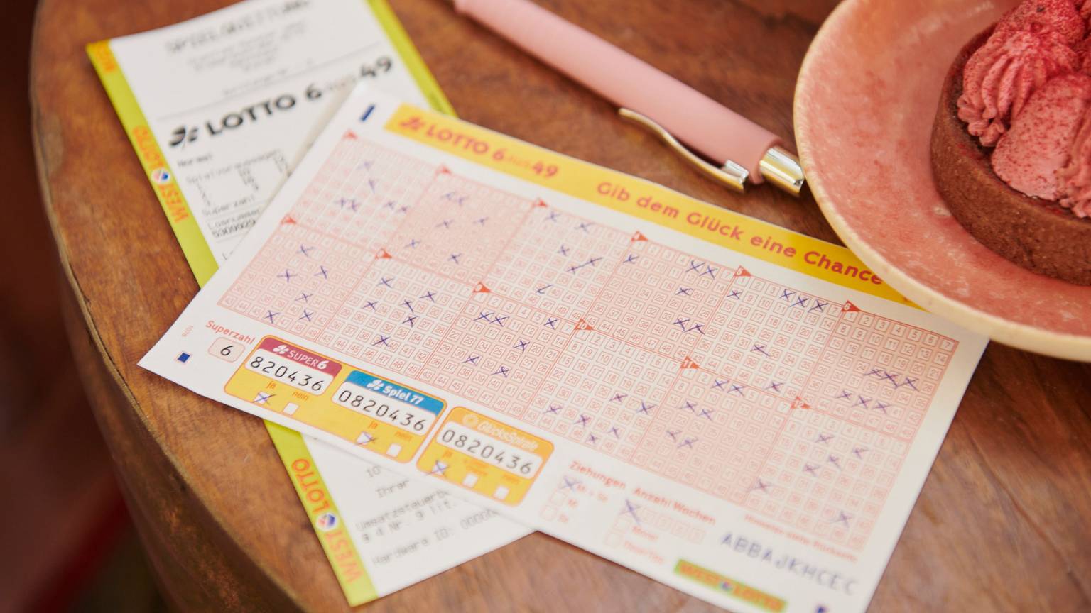 Ein ausgefüllter Lotto 6aus49 Spielschein liegt auf einem Tisch.