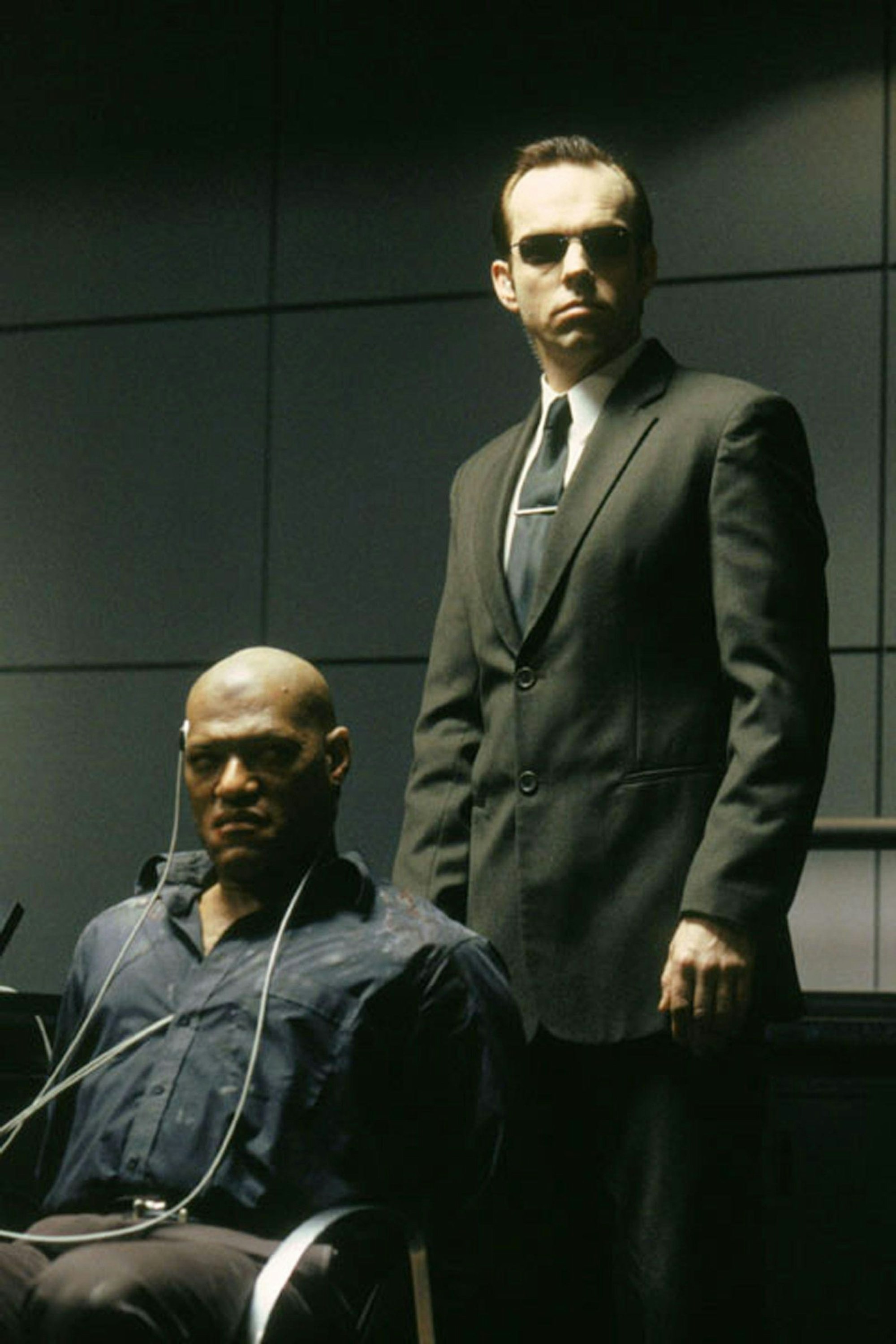 Morpheus (Laurence Fishburne, links) ist in die Fänge von Agent Smith (Hugo Weaving) geraten, der hofft, nun endlich den Widerstand der letzten freien Menschen brechen zu können. (Bild: RTL / 1999 Warner Bros. Entertainment Inc. )