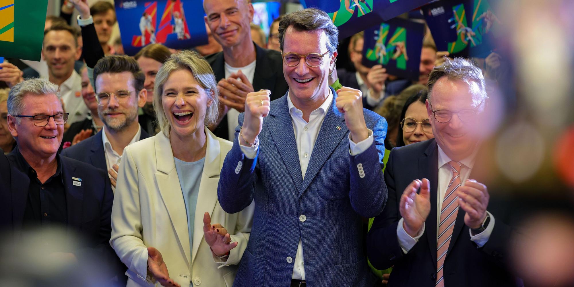 Hendrik Wüst (CDU, Mitte), Ministerpräsident des Landes Nordrhein-Westfalen, jubelt nach der erfolgreichen Abstimmung um die Olympischen Spiele in Köln.