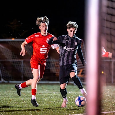 Aaron Mertens schießt, verfolgt vom Gegenspieler, aufs Tor.