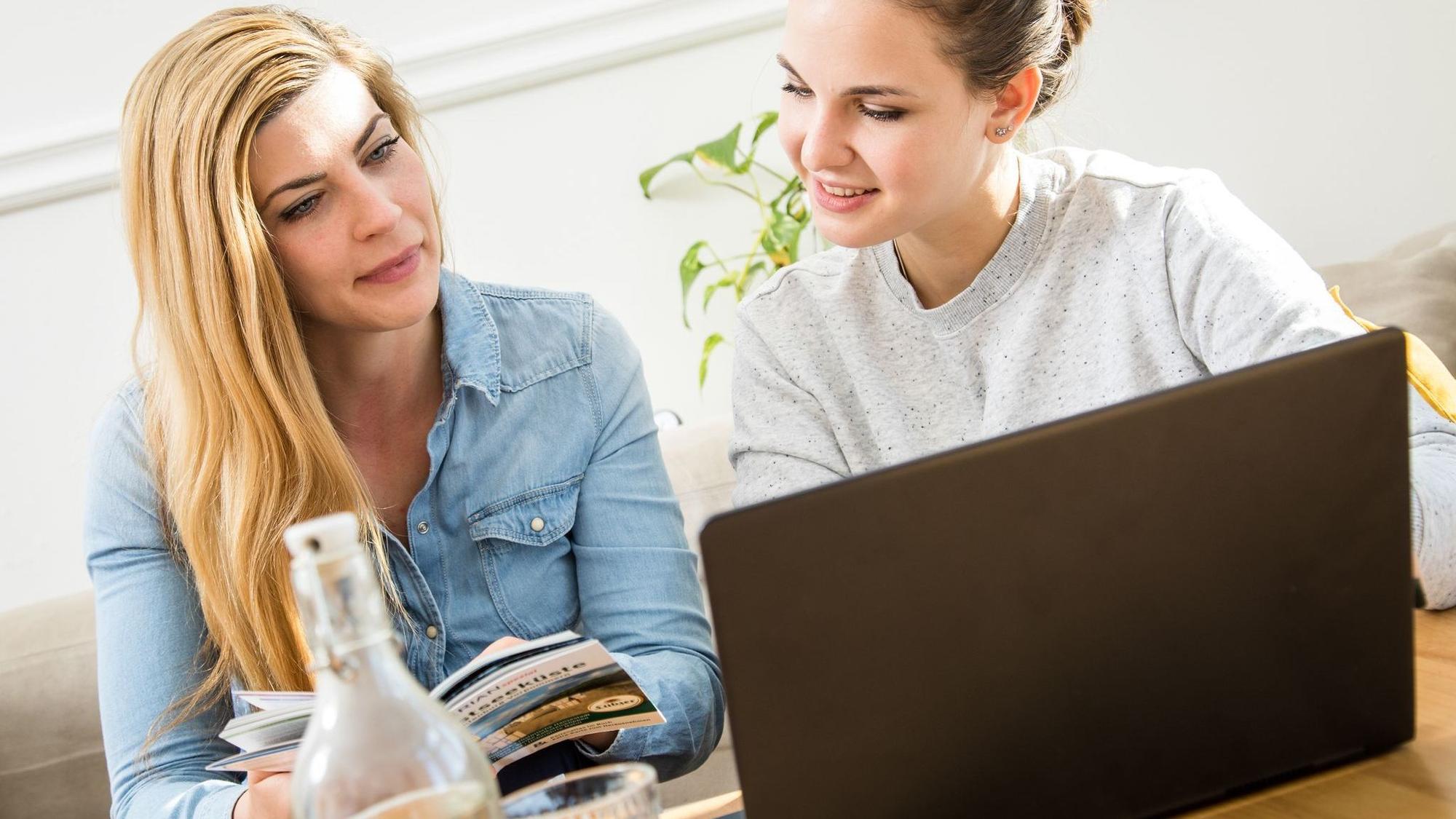 Zwei Frauen buchen online eine Reise