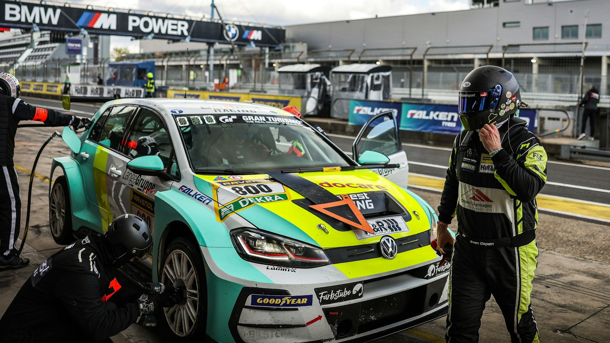 Sven Oepen geht vor dem VW Golf entlang und greift sich an den Helm.