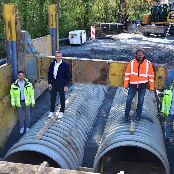 In der Baustelle für den neuen Stauraumkanal in Much stehen Michael Hoppe (Gemeindewerke Much), Bürgermeister Karsten Schäfer, Bauleiter Kai Vogel und Kanalsanierungsberater Johannes Urbach auf den großen Röhren.