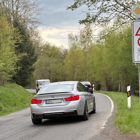 Das Foto zeigt eine Straßenszene von der L198 in Nümbrecht. Am Rand sieht man die Beschilderung, die mit verweis auf Amphibienwanderung die Höchstgeschwindigkeit im Zeitraum zwischen 18 und sechs Uhr auf 50 Stundenkilometer beschränkt.