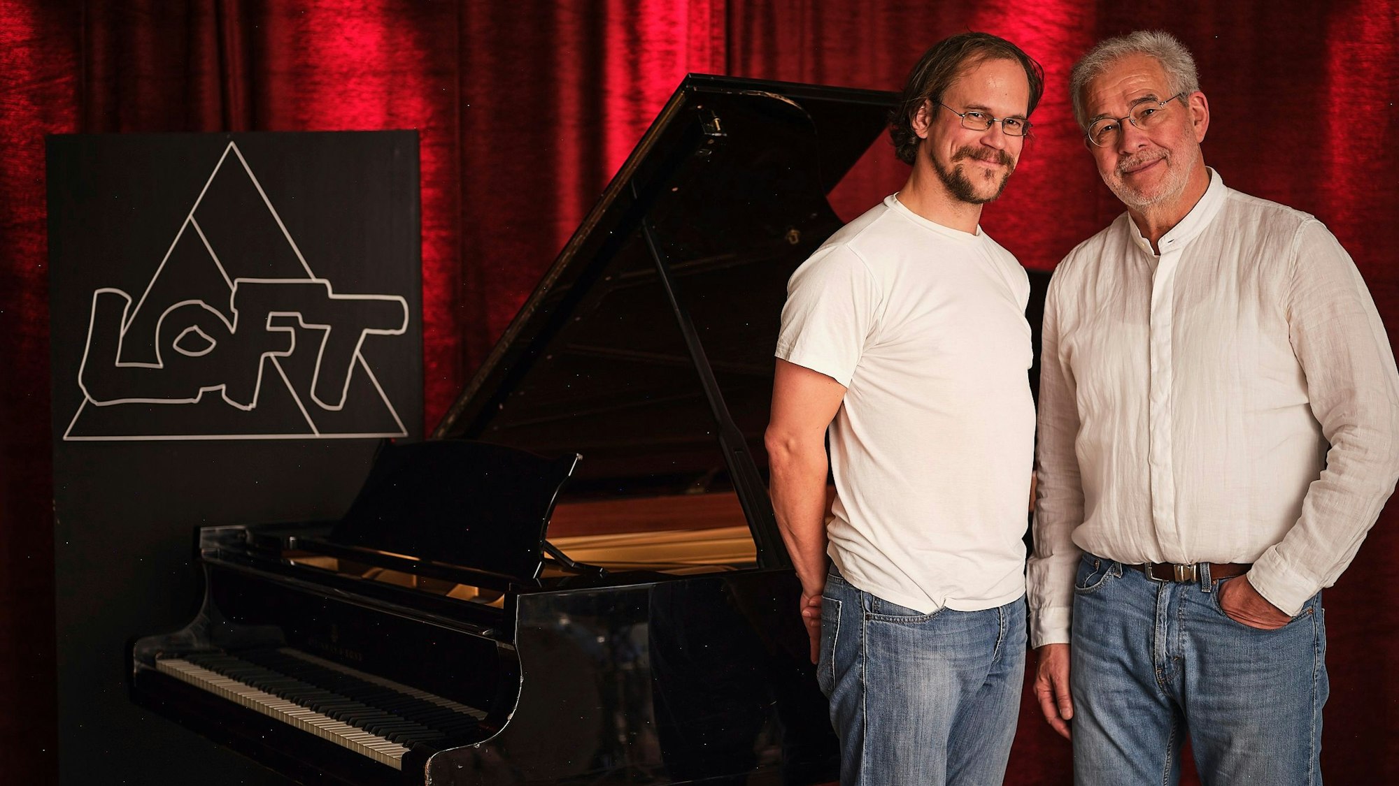 Hans Martin Schmid und Urs Benedikt vor schwarzem Flügel im Loft