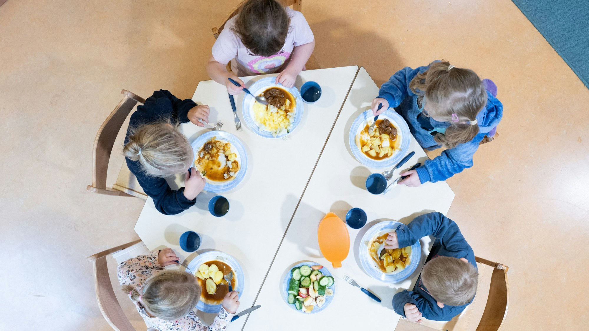Kinder sitzenin einer Kindertagesstätte beim Mittagessen an einem Tisch. (Symbolbild)