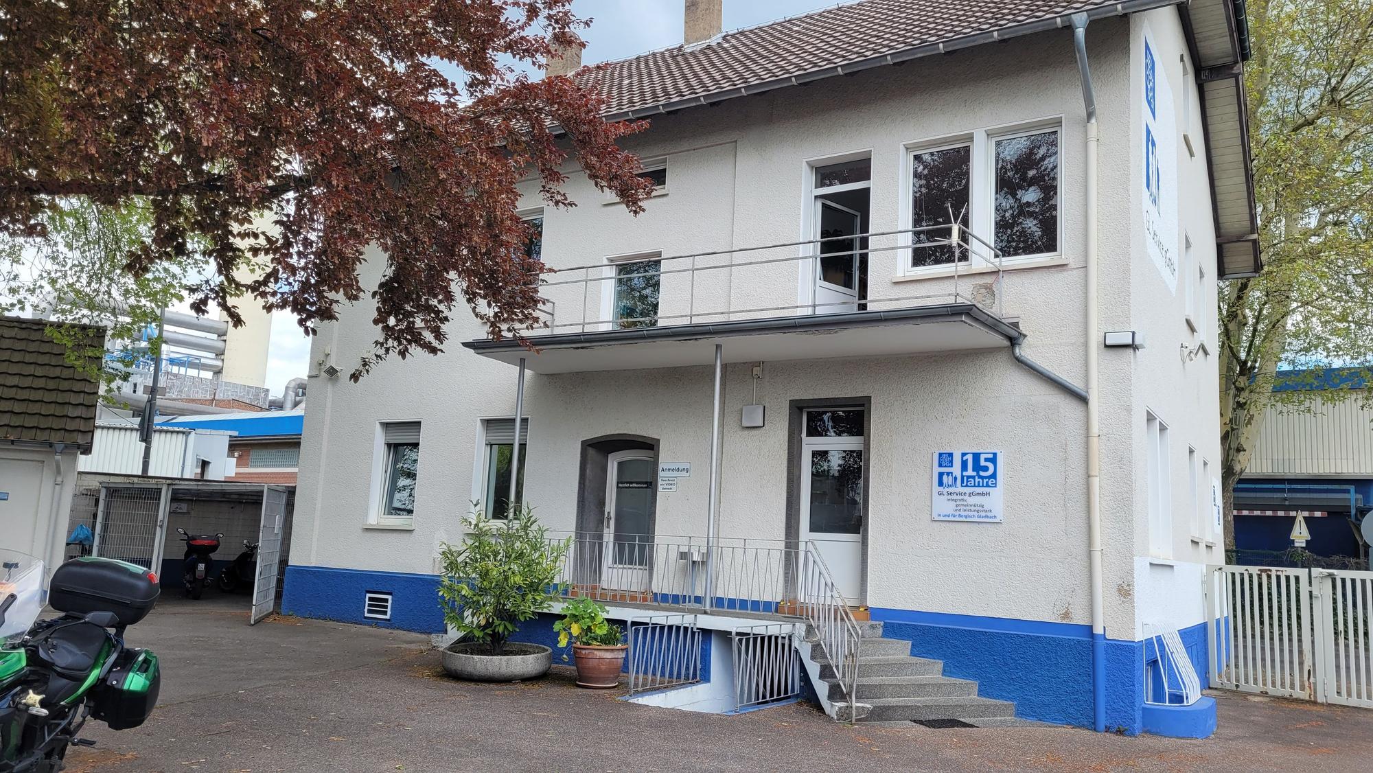 Das Haus der GL Service ist weiß mit einem blauen Fundament.