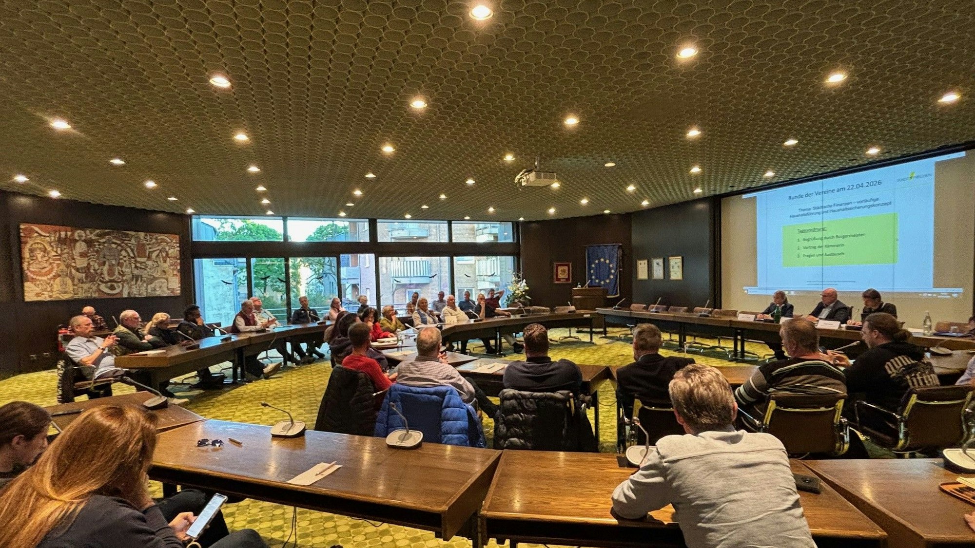 Auf dem Bild ist eine Versammlung im Ratssaal Frechen zu sehen.