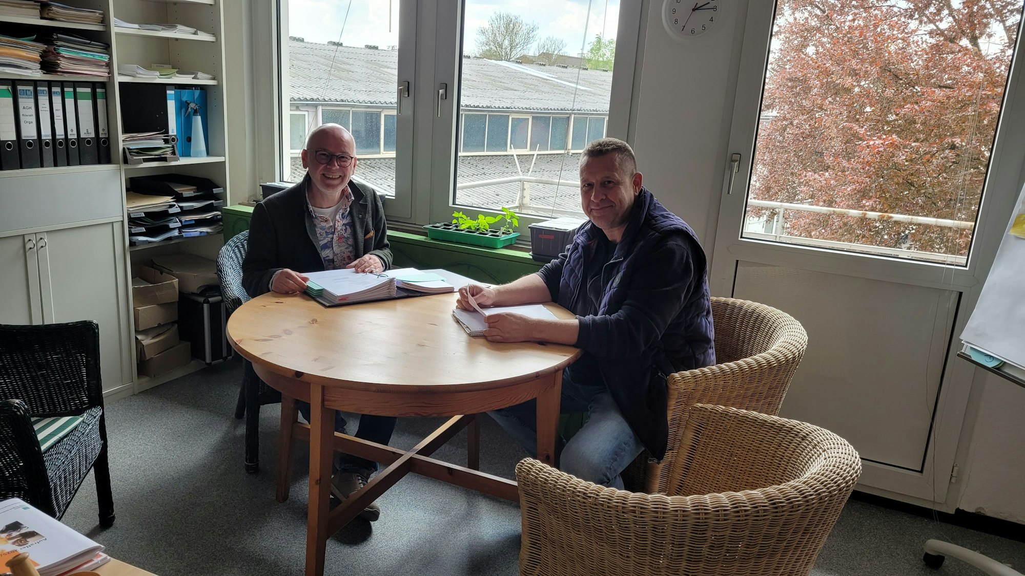 Zwei Männer sitzen an einem Tisch.