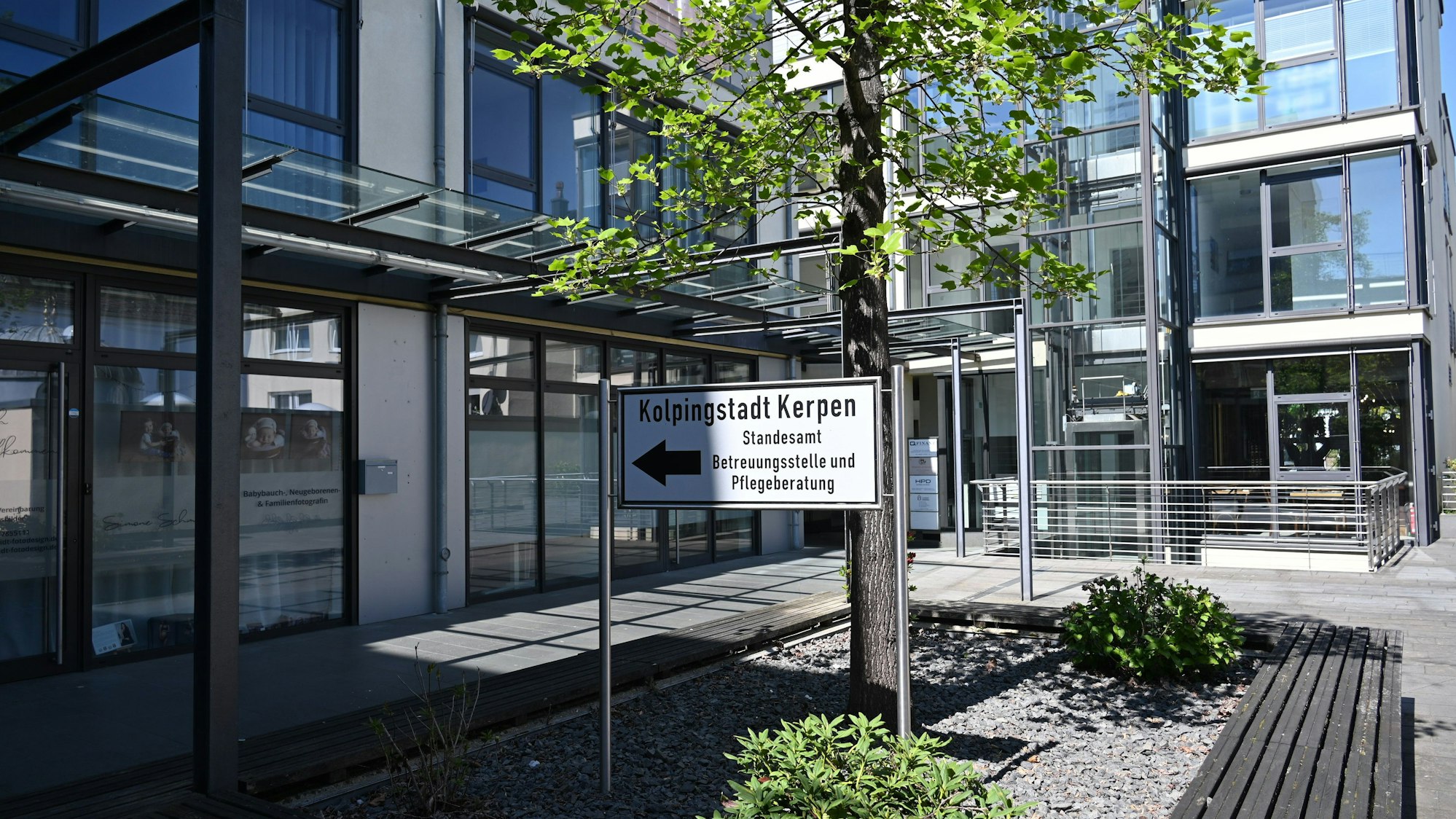 Das Foto zeigt ein Gebäude mit Glasfronten, davor steht ein Schild mit der Aufschrift „Kolpingstadt Kerpen“.