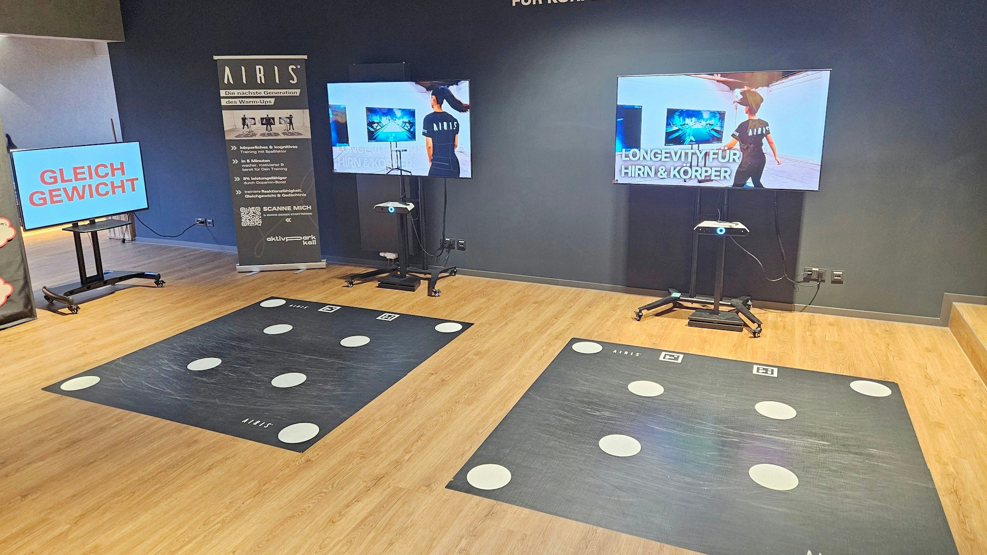 Blick auf zwei große Bildschirme mit Koordinationsmatten davor.