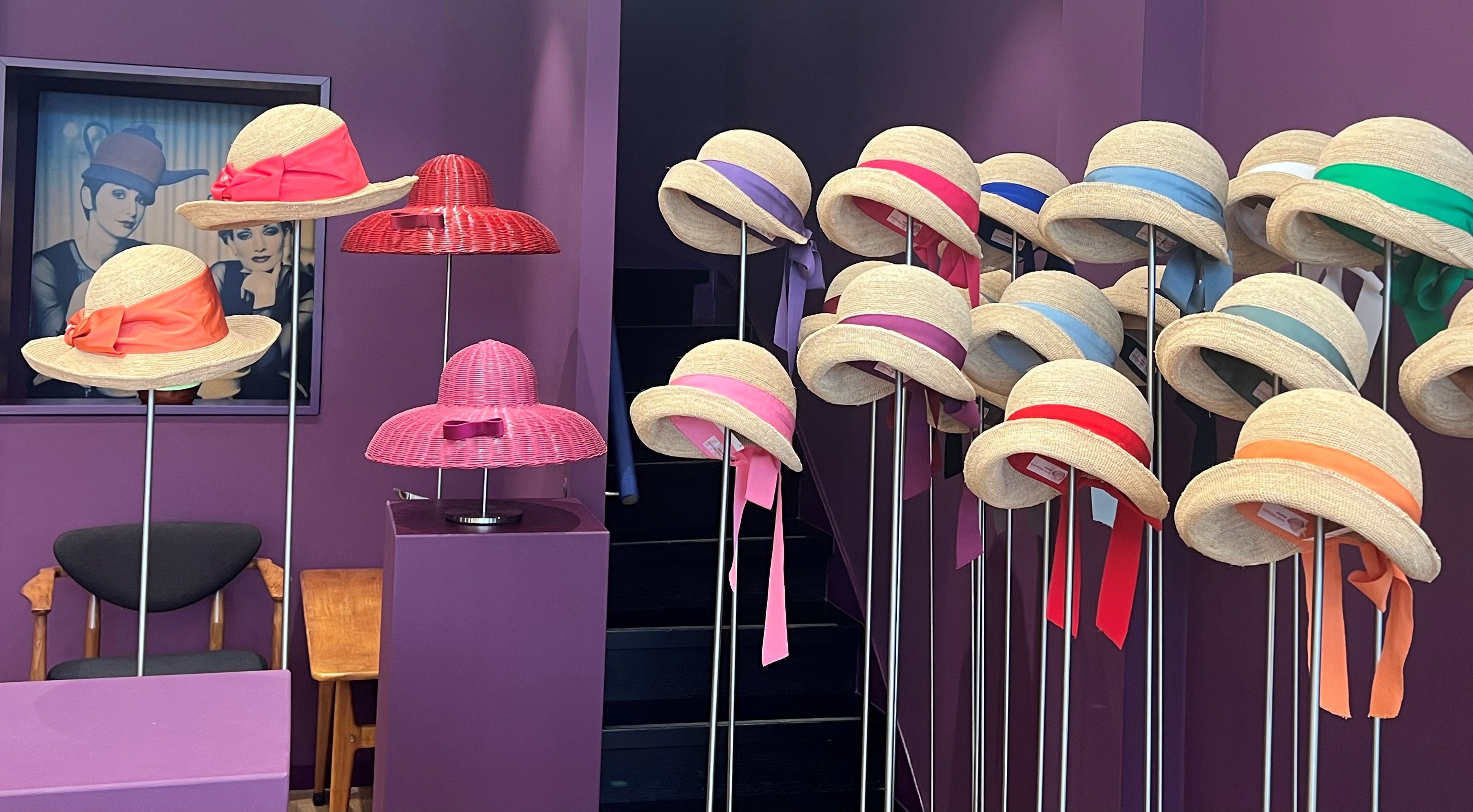 Viele Strohhüte mit unterschiedlich farbigen Bändern sind zu sehen.