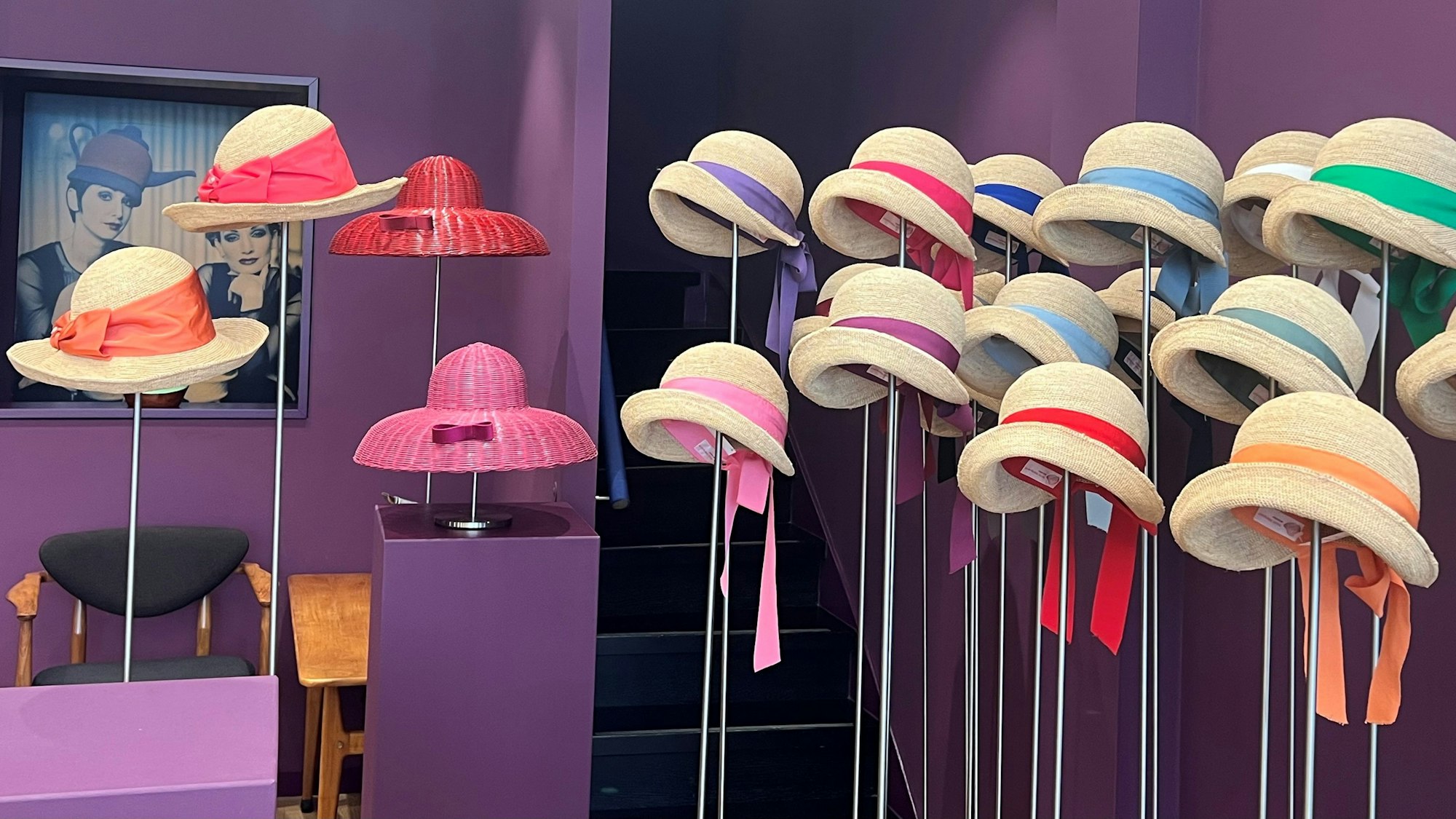 Viele Strohhüte mit unterschiedlich farbigen Bändern sind zu sehen.