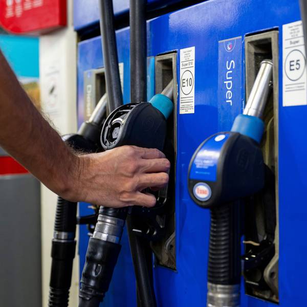 Ein Autofahrer hängt an einer Tankstelle eine Zapfpistole in die Zapfsäule. (Symbolbild)