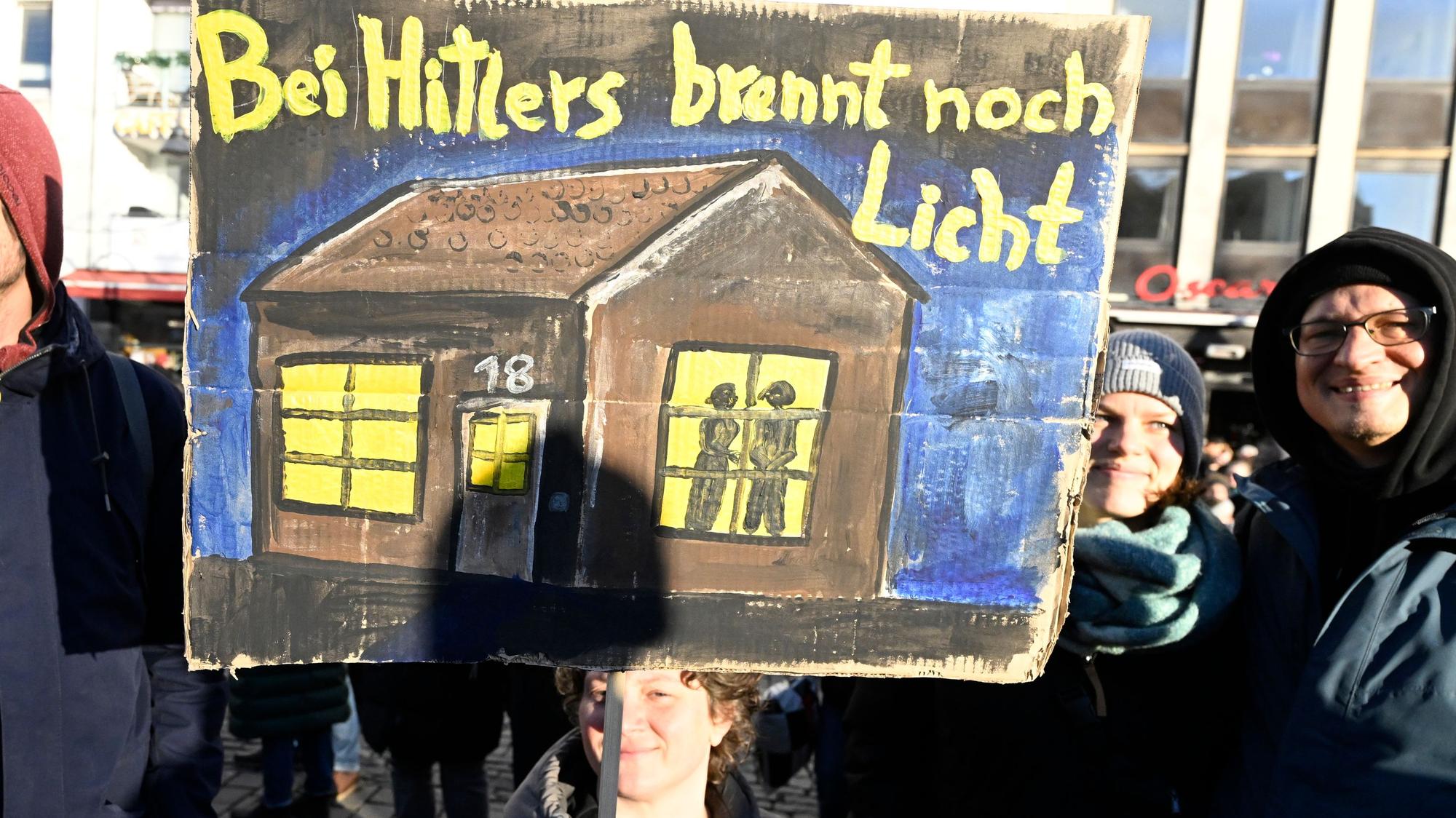 Eine Demonstrantin warnt auf einer Demonstration in Köln 2025 mit einem Plakat „Bei Hitlers brennt noch Licht “vor einer Zusammenarbeit demokratischer Parteien mit der AfD.
