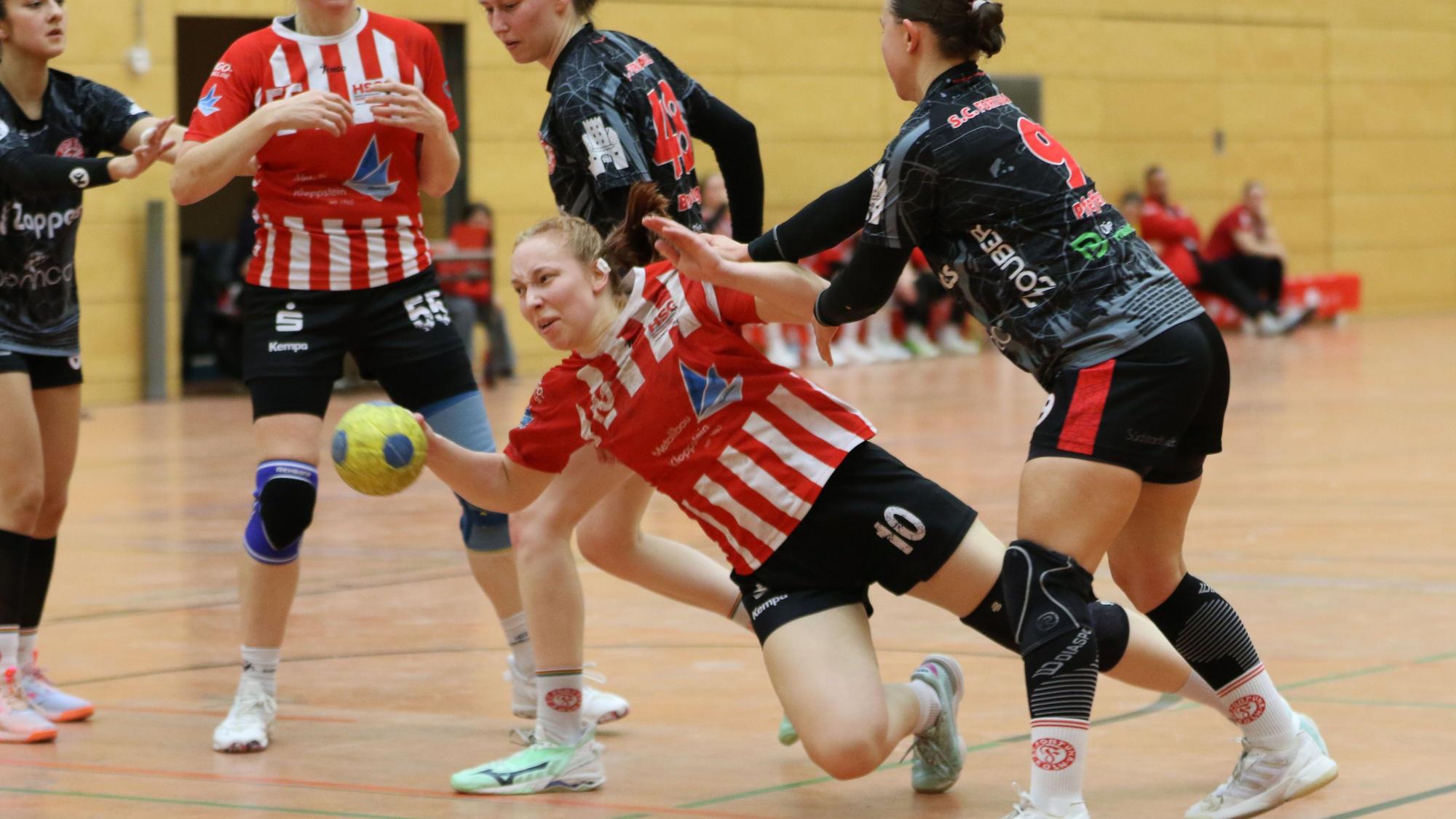 Das Foto zeigt ein Szene aus einem Handballspiel. Kein Durchkommen für Lea Schmitz, die hier unsanft Kontakt zum Boden findet.