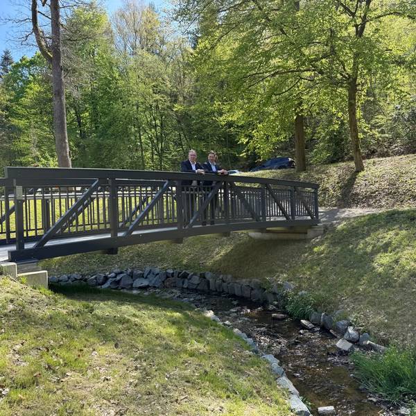 Raoul Halding-Hoppenheit und Hefner stehen auf der neuen Brücke im Hömicker Bachgarten.